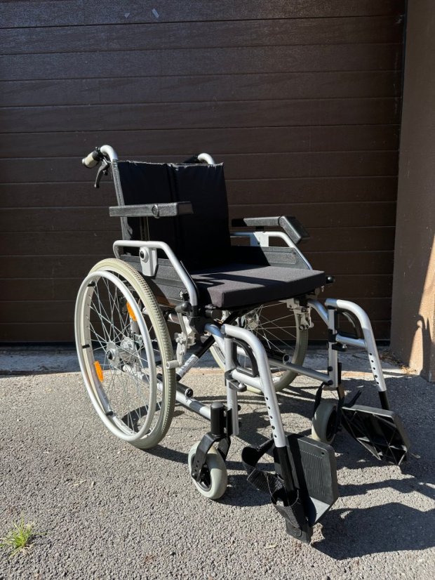 Repasovaný mechanický invalidní vozík venku, skládací konstrukce, plná kola a stabilní rám
