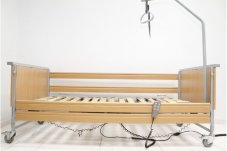 Elektrická postel Domiflex II se světlým dřevěným obložením v nejnižší poloze pro snadný přístup